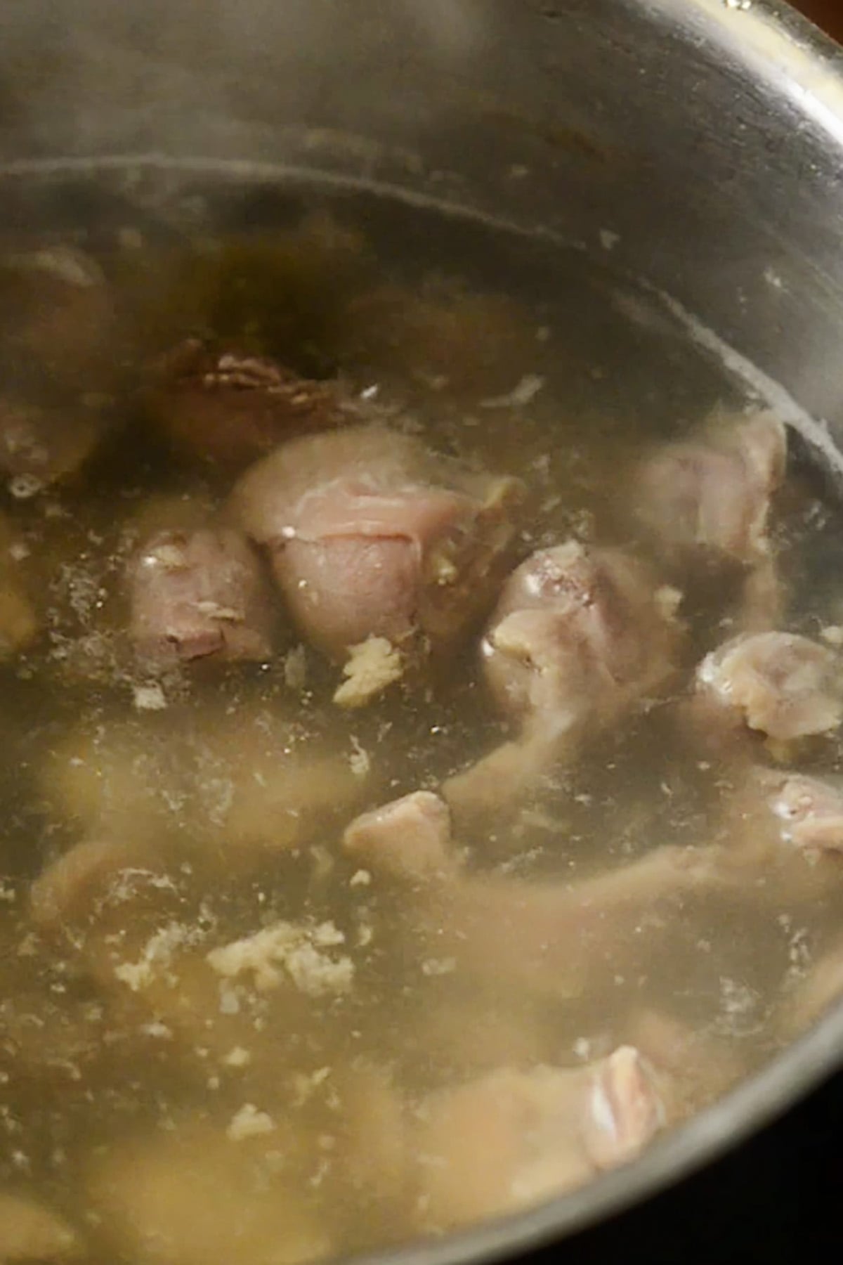 Chicken gizzards being simmered in a pot of water.