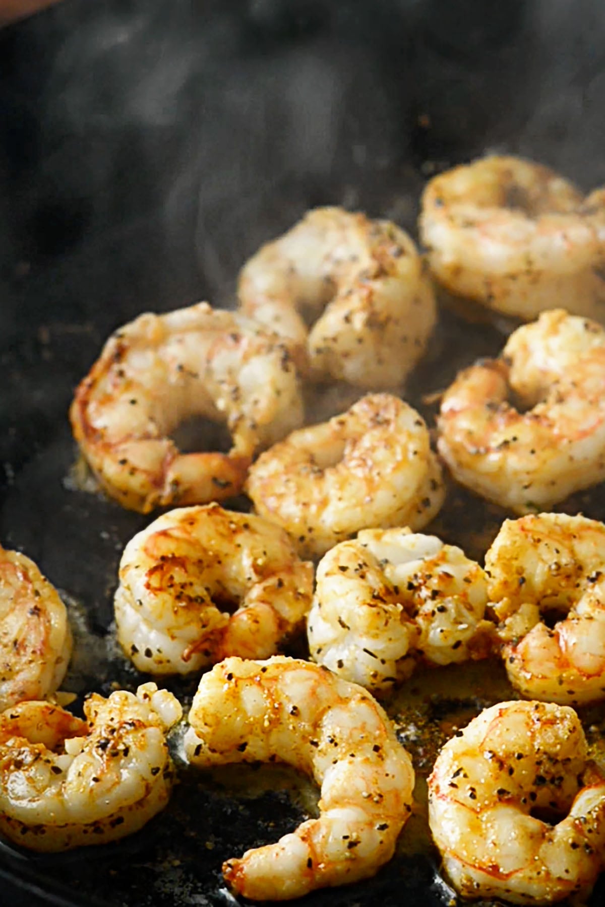 Shrimp cooking in a cast iron skillet.