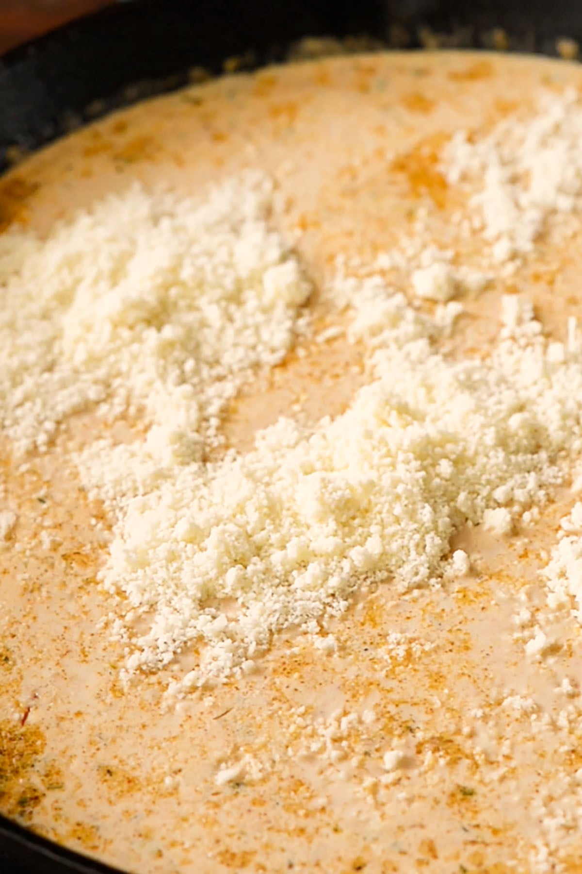Freshly grated parmesan cheese in a creamy cajun pasta sauce.