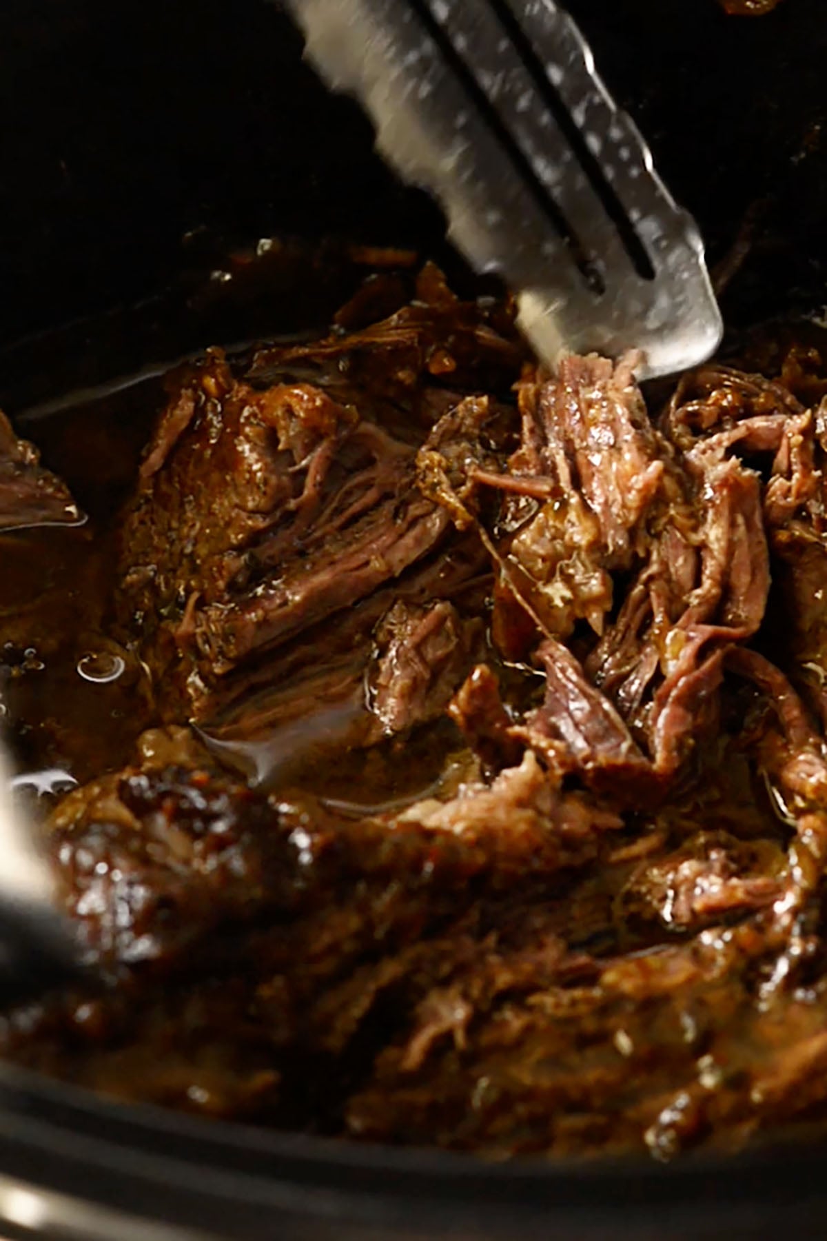 Shredded Mississippi pot roast in a slow cooker.