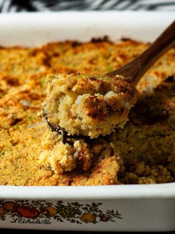 A scoop of southern cornbread dressing in a serving dish.