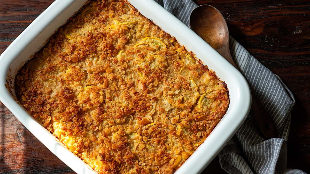 Southern Squash Casserole baked in a vintage white baking dish topped with a crumbly Ritz cracker topping.