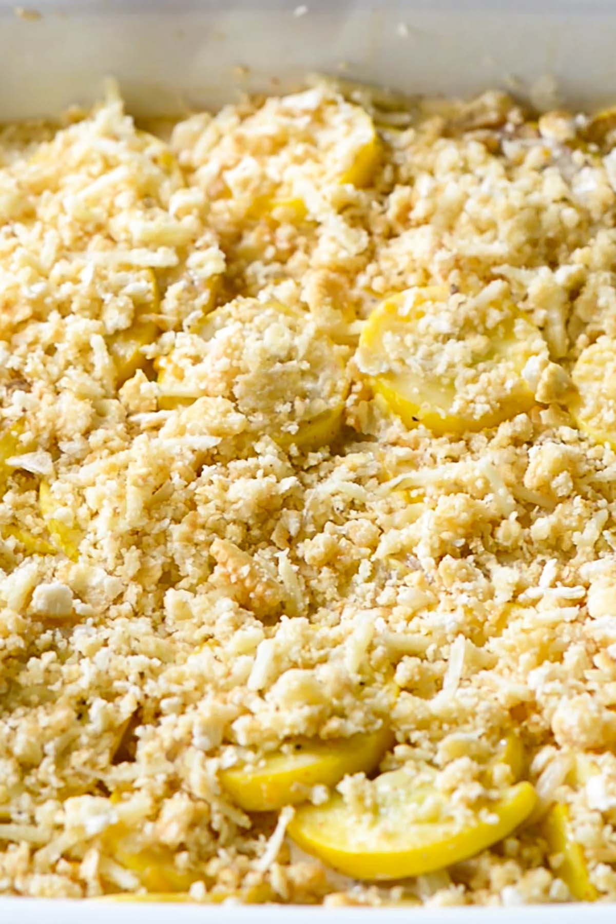 Unbaked squash casserole topped with a crumbled Ritz cracker topping.