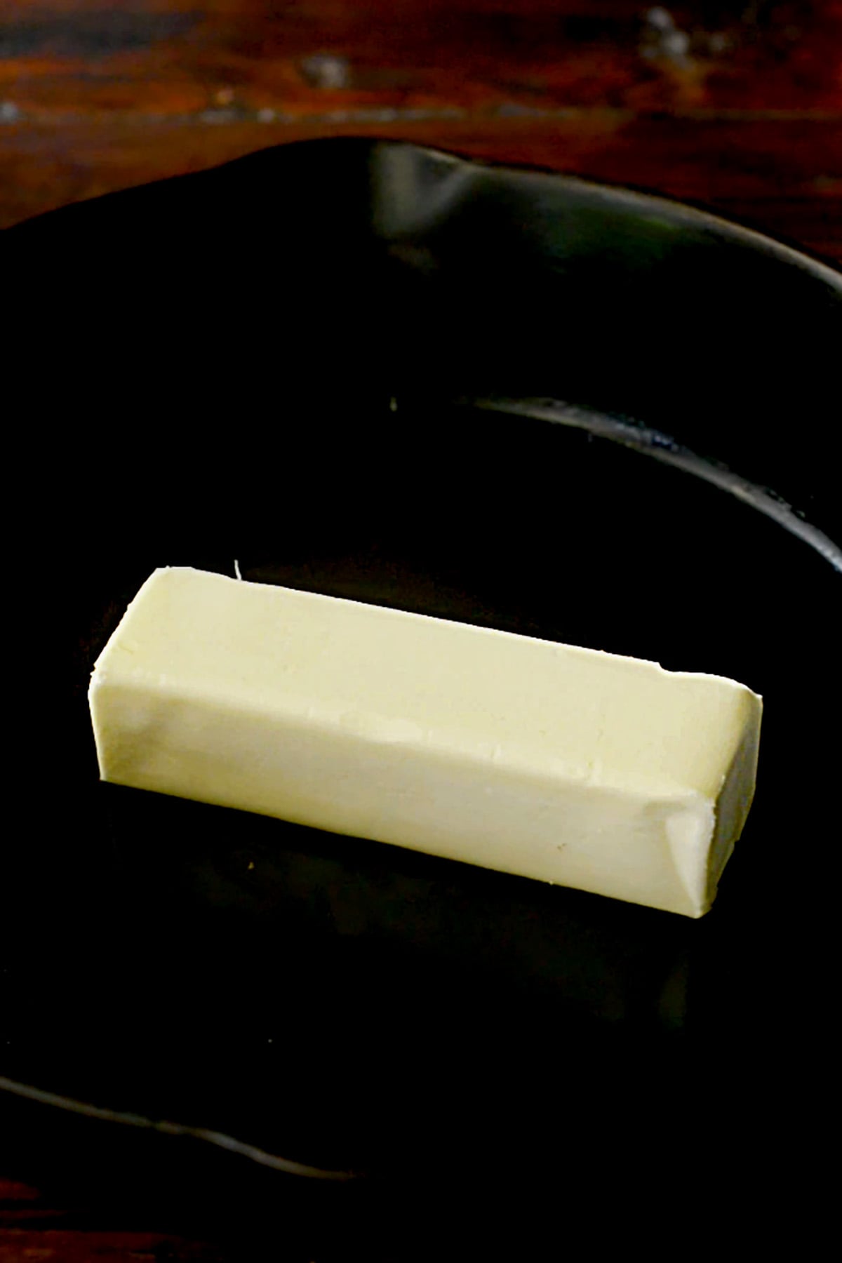 A stick of butter in a cast iron skillet.