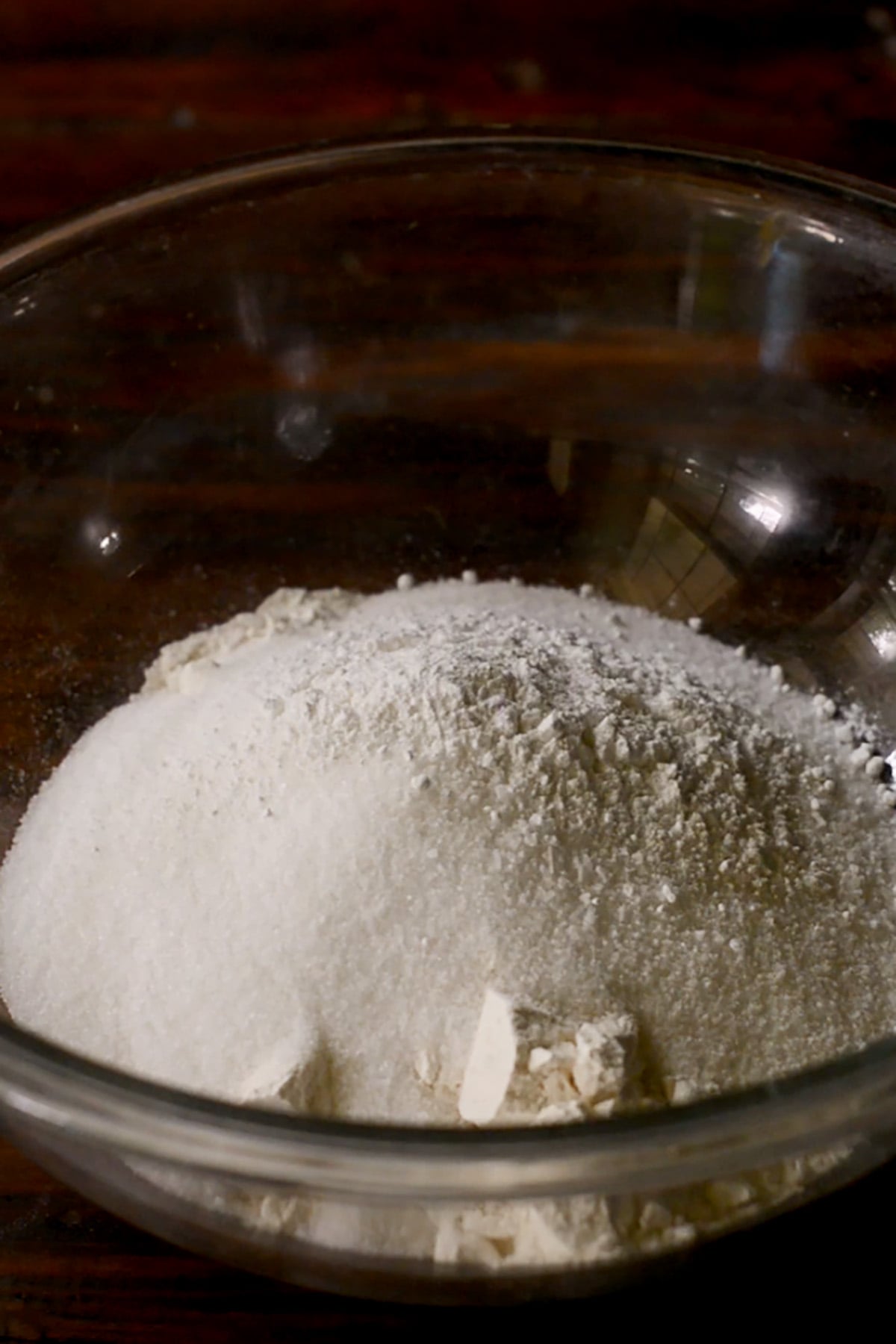 Dry ingredients for a peach cobbler base in a glass mixing bowl.