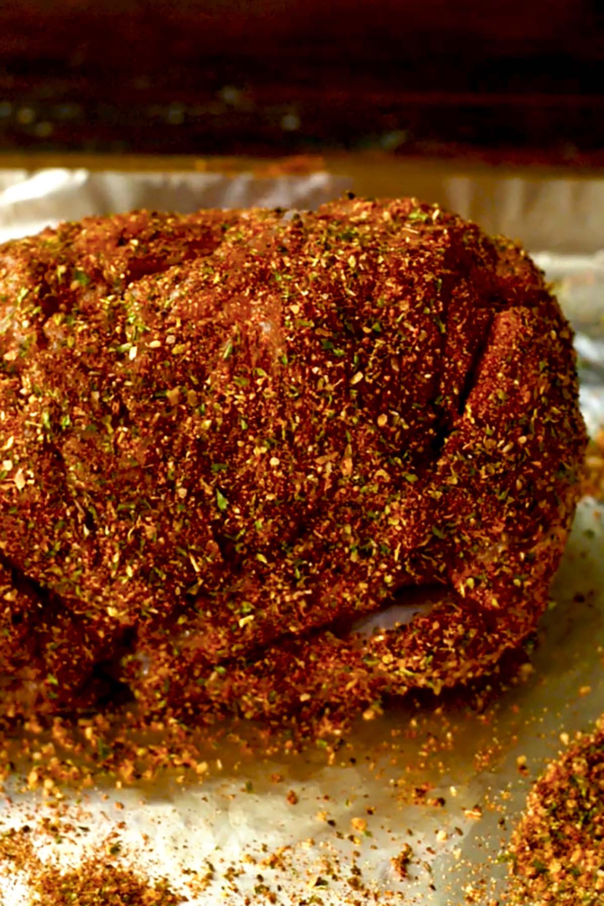 A turkey breast roast seasoned on a foil lined baking sheet.