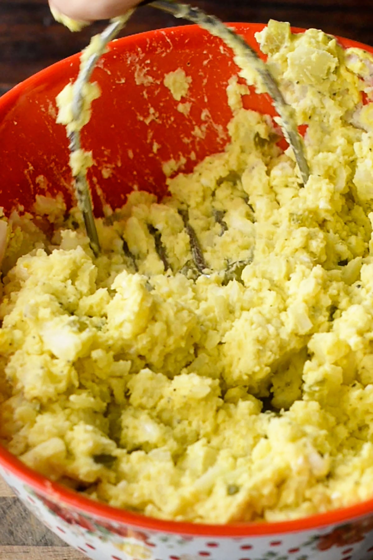 Southern potato salad be mashed using a potato masher in a large mixing bowl.