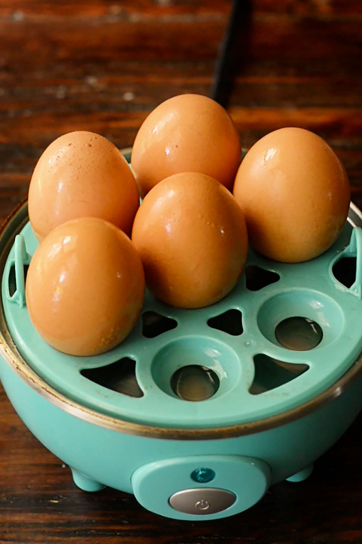 Eggs being placed in an egg cooker to hard boil them for potato salad.