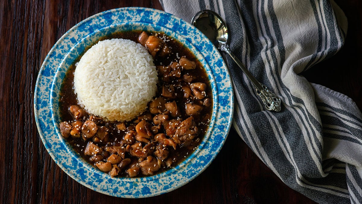 Bourbon chicken served in a vintage bowl with steamed white rice.