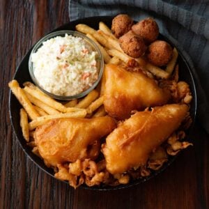 Long John Silver's Copycat fried fish platter served in a black deep dish plate on a wooden table.