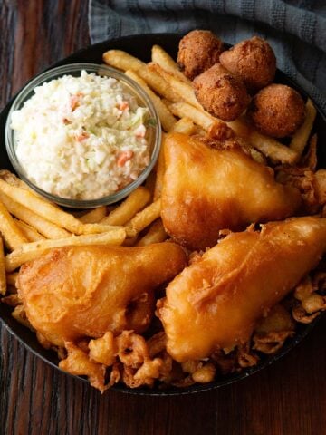 Long John Silver's Copycat fried fish platter served in a black deep dish plate on a wooden table.