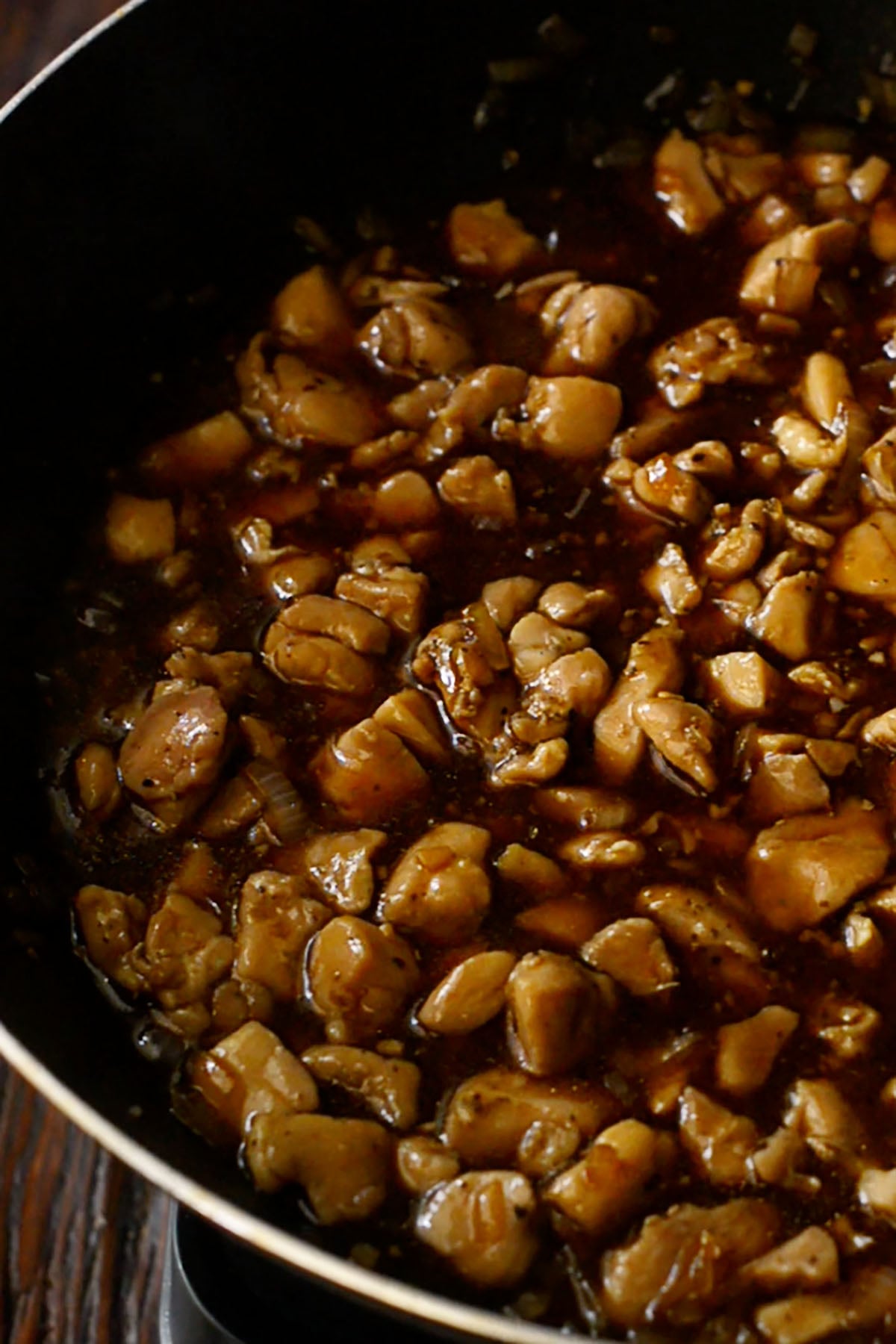 Copycat mall bourbon chicken simmering in a wok.