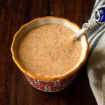 Cajun remoulade served in a ramekin with a small serving spoon.