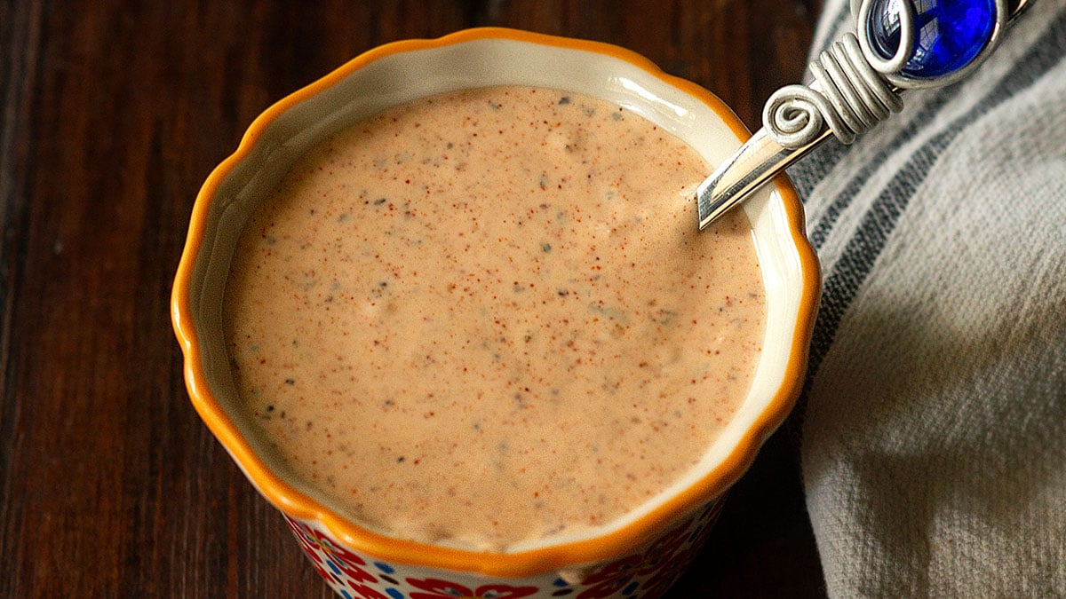 Cajun remoulade in a colorful ramekin with a sauce spoon.
