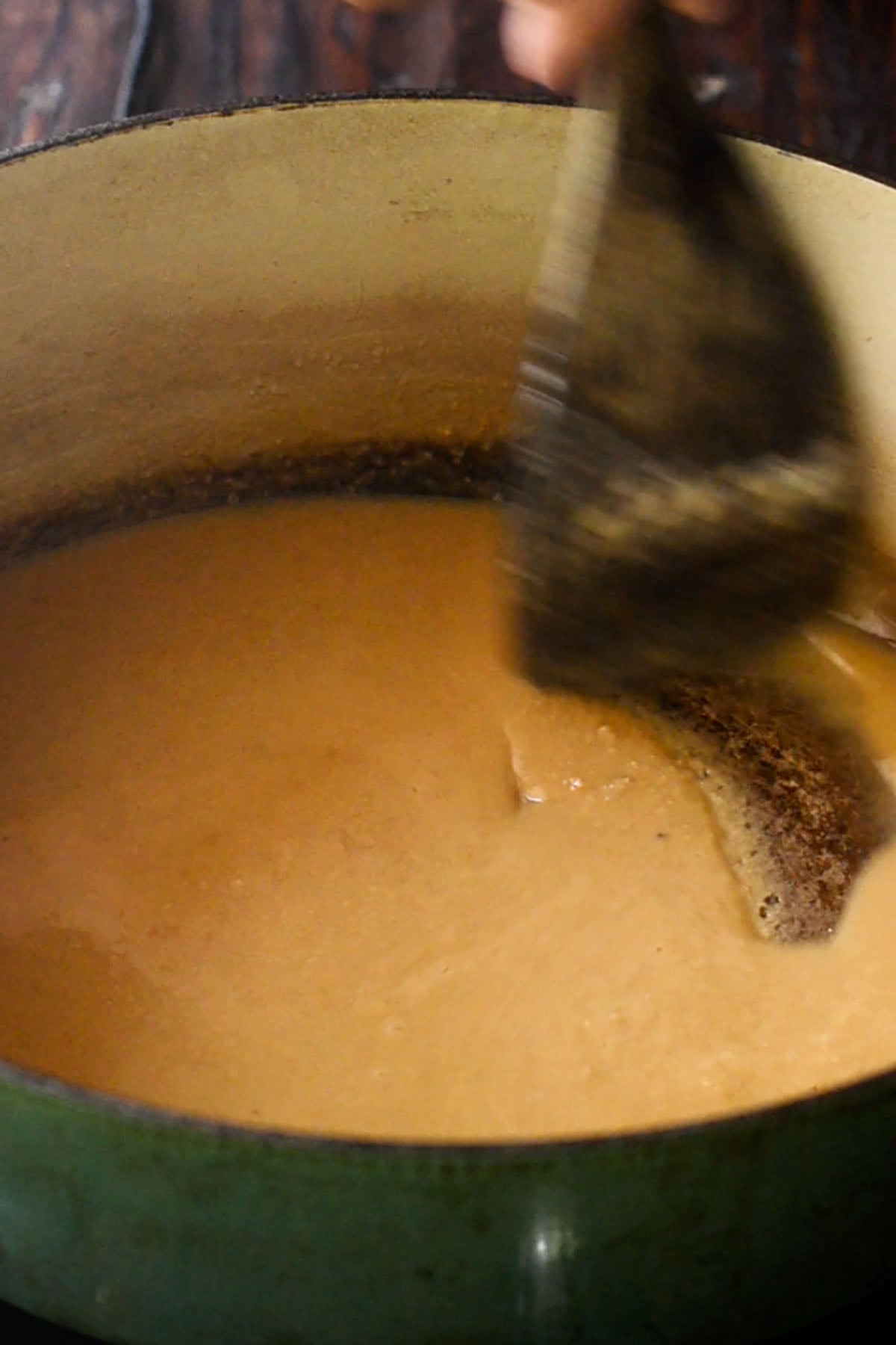 Roux for chicken and sausage gumbo being stirred in an enameled cast iron dutch oven.