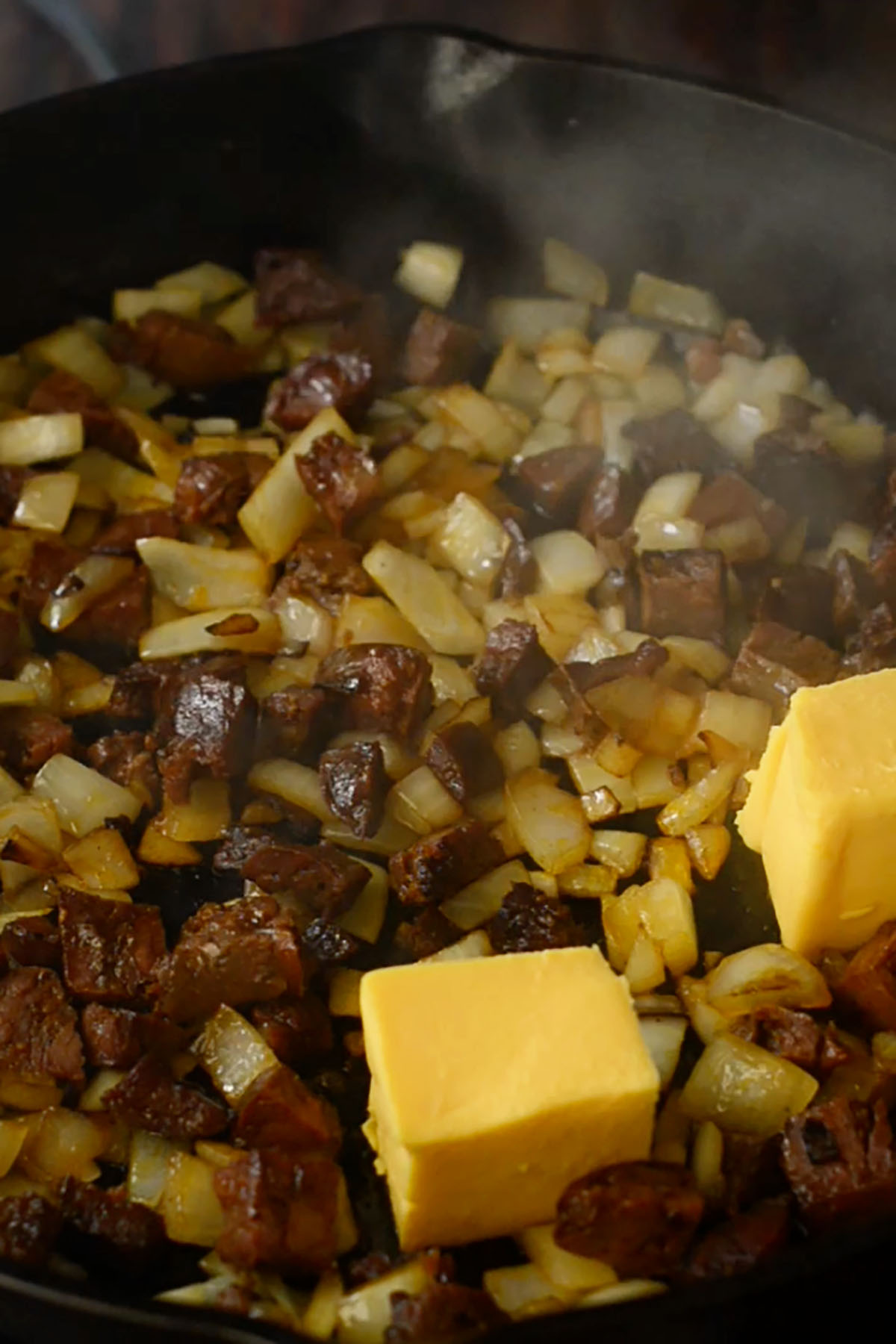 Browned chorizo and onions in a cast iron skillet with a couple cubes of Velveeta Cheese.