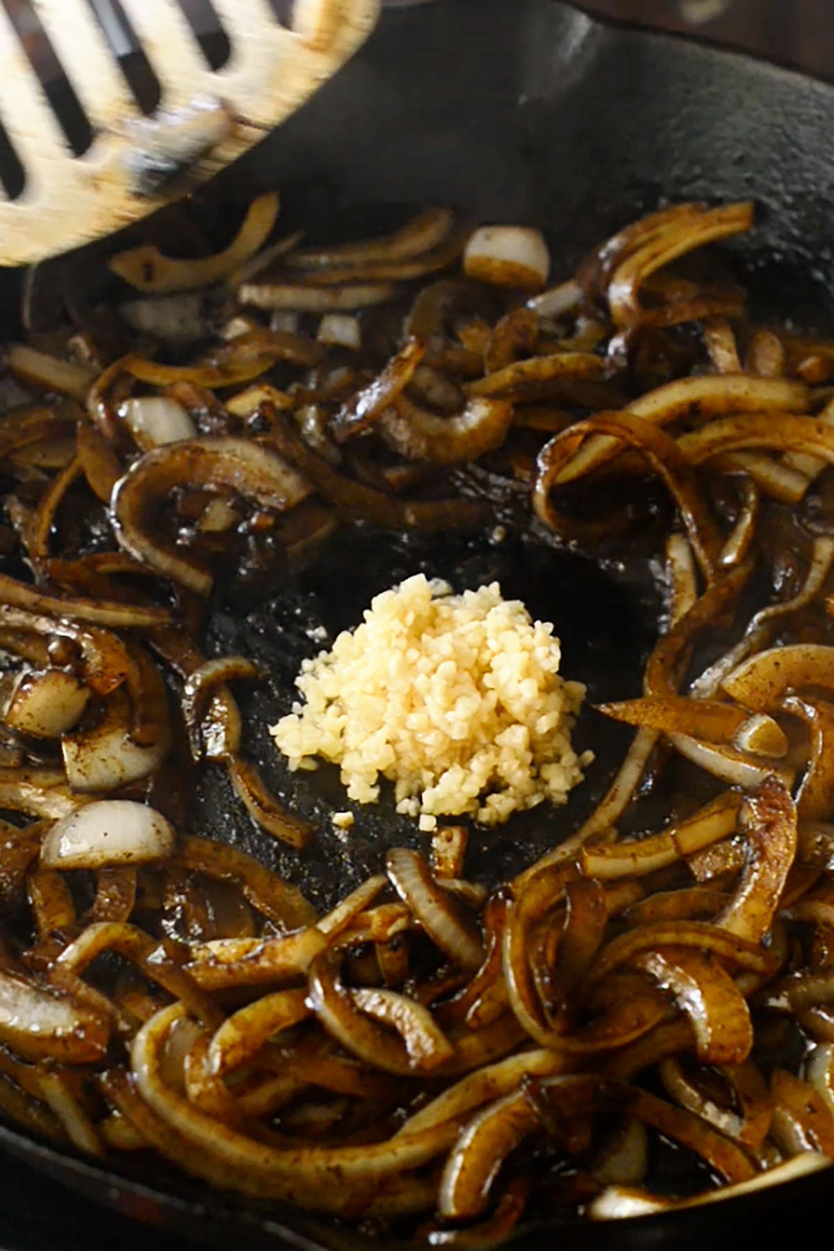 Onions and garlic cooking in a cast iron skillet.