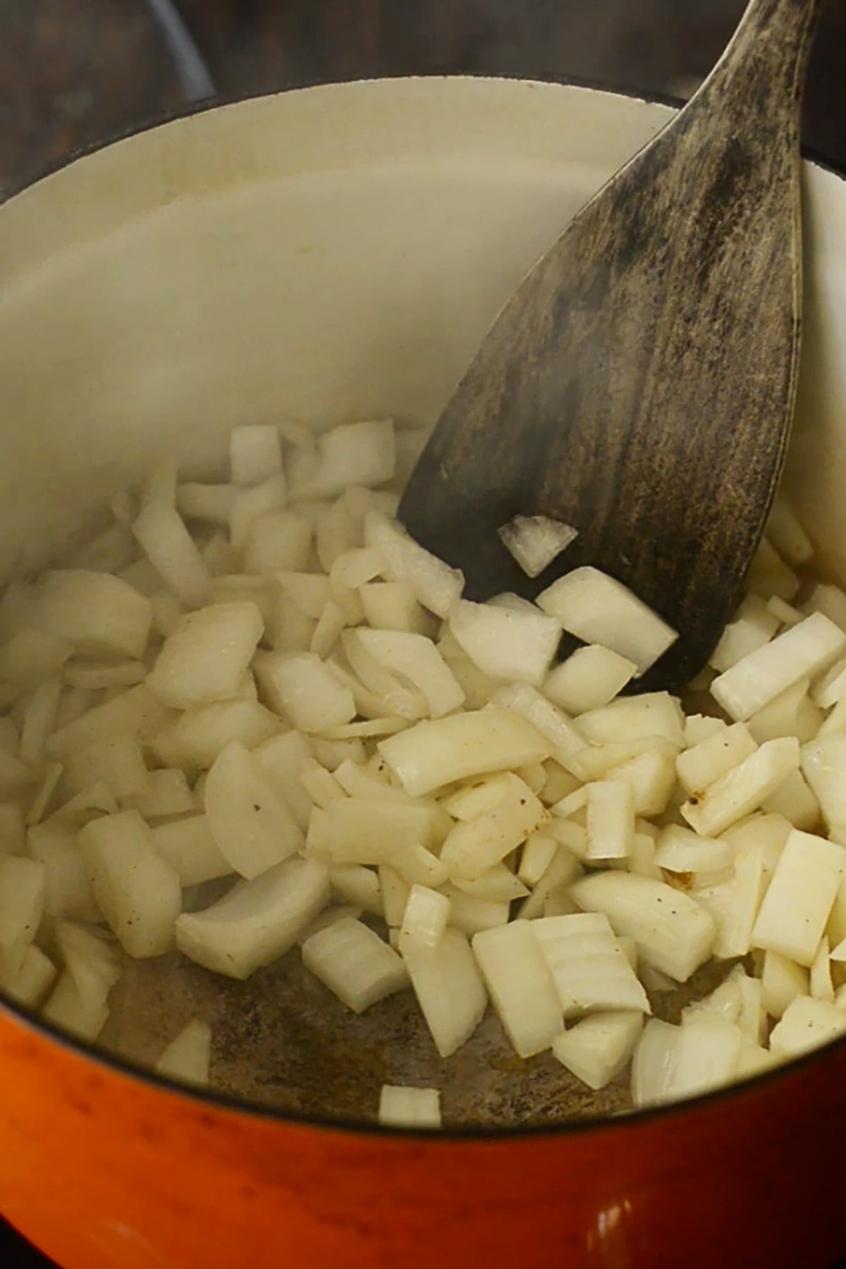 Diced onions sautéing in an enameled cast iron dutch oven.